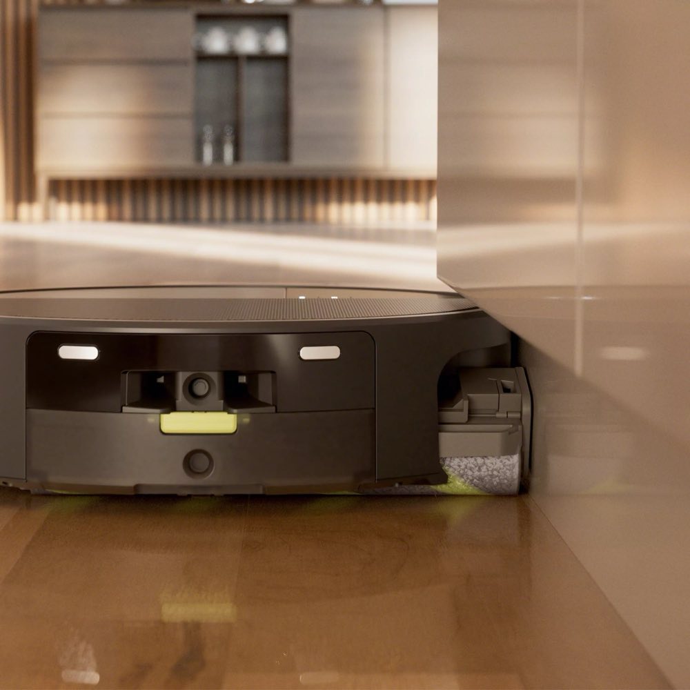 Edge sweeping brush of the Roomba Max 705 cleaning along baseboard